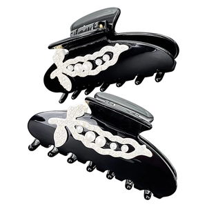 Detailed view of black acetate hair claw clip with pearl pea pod design and rhinestones