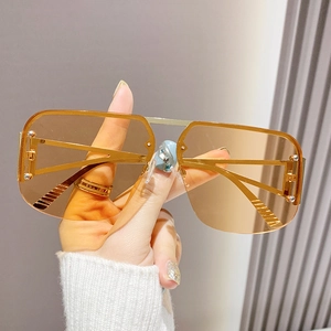 Fashionable pilot metal sunglasses with gold frame and brown gradient lenses in hand