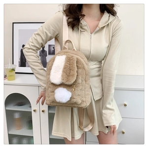 Detail of plush rabbit ears and soft khaki faux fur texture on the cute girls backpack