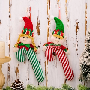 Close-up of plush Christmas elf candy cane hangers on a rustic wooden background