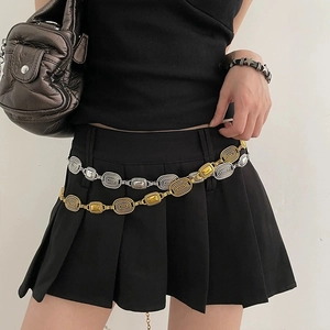 Retro mixed metal link belt with carved textures and Y2K aesthetic on black skirt