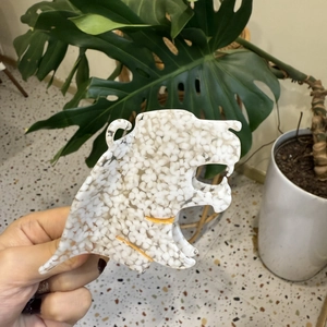 Detailed view of leopard head hair claw clip made of white acetate with gold accents