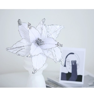 White Christmas poinsettia flower with silver sequins in a minimalist white vase decoration
