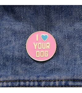 Detail of round 'I LOVE YOUR DOG' enamel pin on blue denim fabric with gold plating