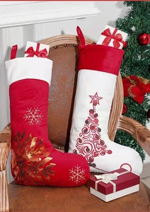 Detail von roten und weißen Samt-Weihnachtssocken mit Stickereien von Schneeflocken