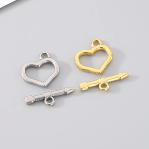 Macro detail of gold and silver heart-shaped toggle clasps for jewelry making