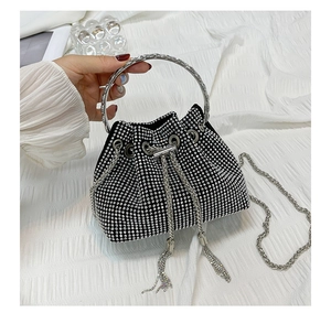 Detail of black rhinestone drawstring bucket bag with metal ring handle and chain strap