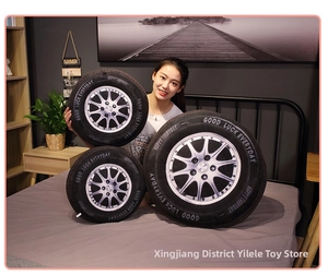 Detail shot of three 3D tire plush cushions in various sizes on a bedroom background