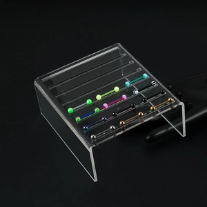 Vue macro de piercings industriel multicolores sur un support de présentation acrylique