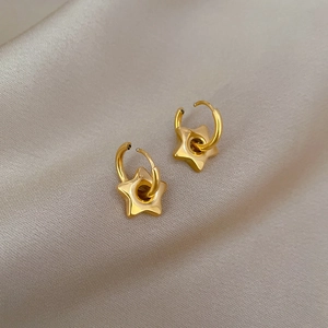 Minimalist gold star stud earrings in titanium steel on an elegant silk background