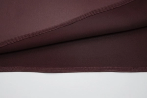 Detailed close-up of dark purple lace fabric with professional stitching and seam finish
