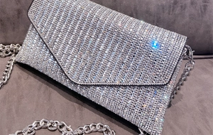 Detailed macro view of silver rhinestone clutch with square crystals and chunky chain strap