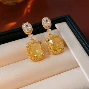 Detail of 18K gold plated earrings with yellow square stone and crystal halo in a box