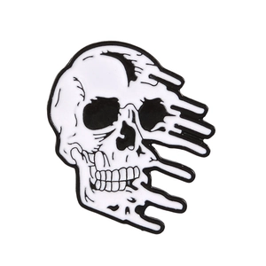 Détail d'un pin's en émail en forme de crâne avec effet fondant noir et blanc