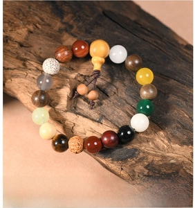 Detailed view of eighteen seed Buddhist prayer beads with tassels on vintage wood