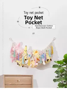 Close-up of handmade cotton rope storage net with colorful tassels on a white wall