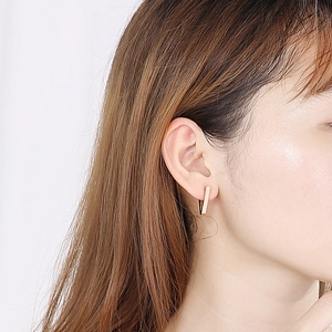 Close-up of a model wearing the minimalist rose gold geometric U-shaped earrings
