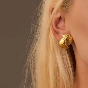Detail of 18K gold-plated titanium steel earrings with hammered texture on earlobe