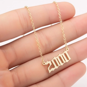 Detailed shot of gold-plated year 2000 pendant on a dainty link chain for women