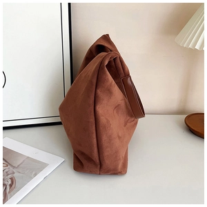 Close-up of soft brown suede tote bag texture with wide leather shoulder strap