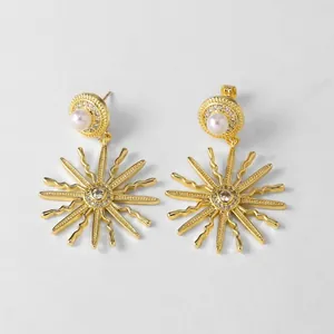 Détails de boucles d'oreilles étoile dorée avec perles blanches et cristaux de zircone