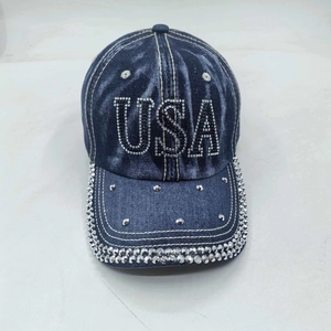 Close-up of USA sequin lettering and rhinestone edges on dark blue washed denim cap