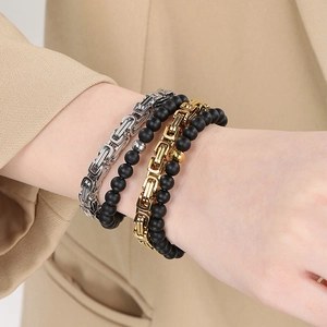 Detail of stacked titanium steel imperial chains and black onyx bead bracelets on wrist