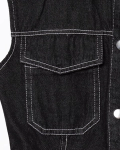 Detail of black denim dress with white contrast stitching and silver metal button