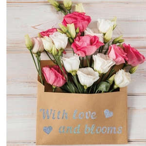 Detail view of pink and white flowers in a brown kraft envelope with glittery text