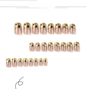 Detailed flat lay of French style press-on nails with gold tips and black stars