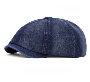 Detail of dark blue denim newsboy cap showing washed texture and contrast stitching
