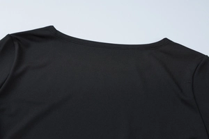Detail des schwarzen Rundhalsausschnitts und der Doppelnaht am Kleid aus Feinstrick
