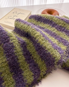 Close-up of the soft purple and green striped wool texture on a stylish knit scarf