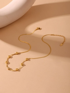Close-up of a gold snake chain necklace with heart sliders and diamond accents