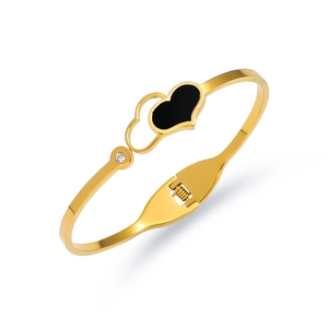 Detail of gold-plated heart bracelet with black enamel, white zircon, and spring hinge