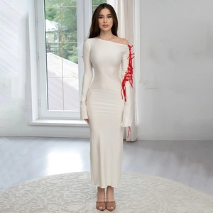 Detail of elegant beige off-shoulder maxi dress featuring red lacing on the sleeve