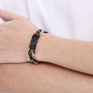 Gros plan du bracelet chaîne en acier titane tricolore noir, argent et or au poignet