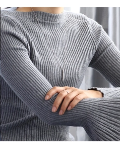 Minimalist silver cylinder pendant necklace with a fine chain worn on a grey sweater