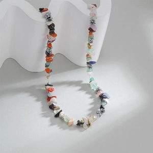 Colorful bohemian natural stone gravel necklace displayed on white wavy decor stand
