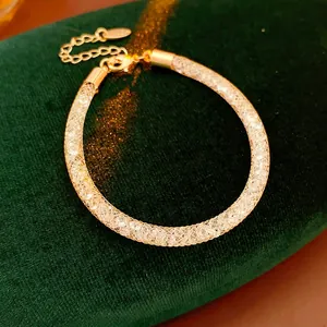 Elegant gold mesh bracelet filled with sparkling crystals on deep green velvet