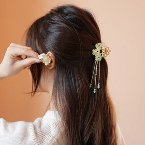 Detailed back view of a butterfly hair claw with pearl tassels and floral clip on hair
