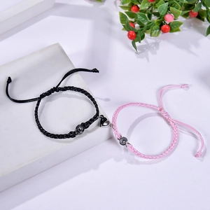 Detail of magnetic heart charms and projection stones on woven couple bracelets