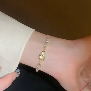 Adjustable gold pull-bracelet with zircon hulu charm and yellow cat-eye gemstone