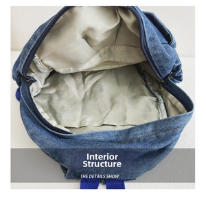 Detail view of the vintage denim backpack interior with gray lining and zipper pocket