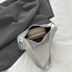 Silver metallic pleated crescent bag showing spacious interior capacity for phone and wallet