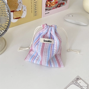 Close-up of pink and blue striped drawstring pouch with Sozakka label on a white desk