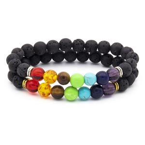 Detail of seven chakra energy bracelets with black lava stones and colorful beads
