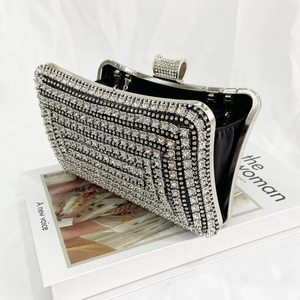 Close-up of a silver rhinestone evening clutch bag with black satin lining and crystal clasp