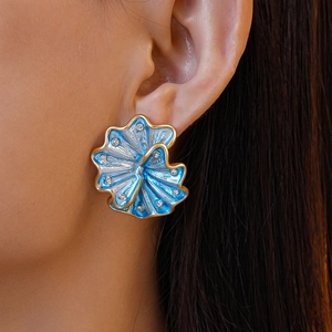 Close-up of royal blue enamel flower earring with gold edges and sparkling crystals