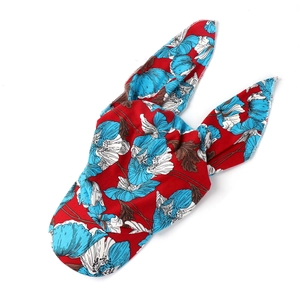 Detailed view of red floral turban hat featuring blue flower patterns and rabbit ear knot
